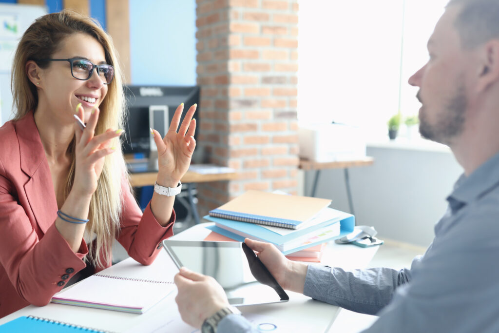 A male and female sitting at a desk discussing outsourced accounting